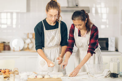 Women standing on cutting board at home