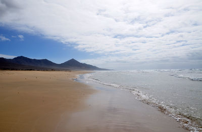 Scenic view of sandy beach against sky