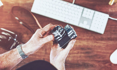 Cropped image of men holding camera