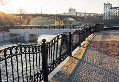 Bridge over river in city against sky