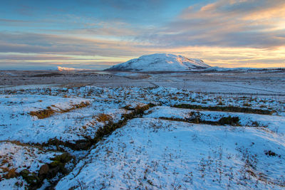 Scenic view of snowcapped mountains against sky during sunset