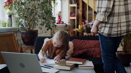 Teacher looking at girl doing homework