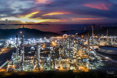 Oil refinery and petroleum industry factory zone at night over lighting with the sea 