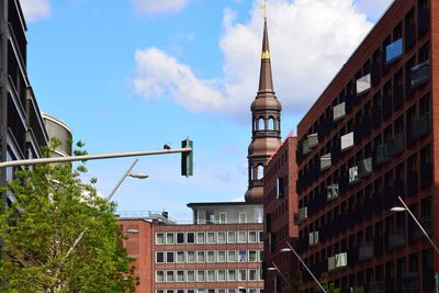 Low angle view of buildings against cloudy sky