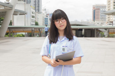 Young female doctor standing in city