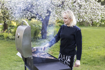 Woman making barbecue at backyard