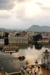 High angle view of buildings by river against sky