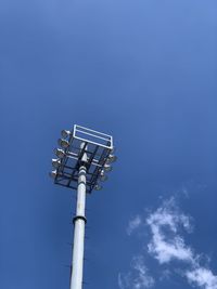 Low angle view of floodlight against blue sky