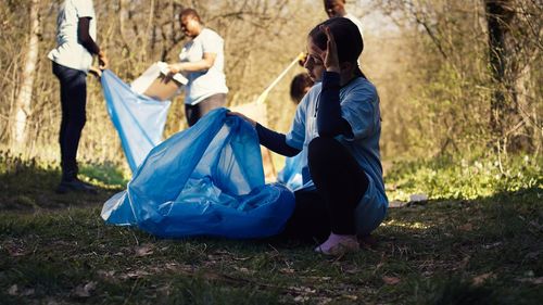 Rear view of woman sitting on field