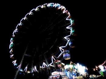 Low angle view of illuminated ferris wheel against sky at night