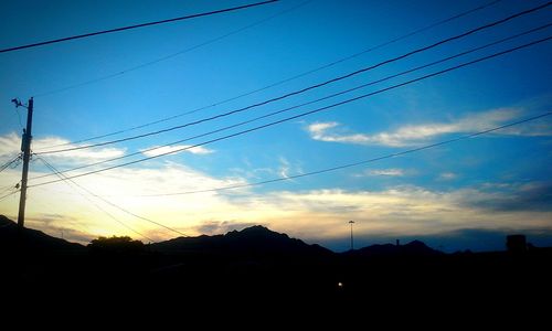 Low angle view of electricity pylon against sky