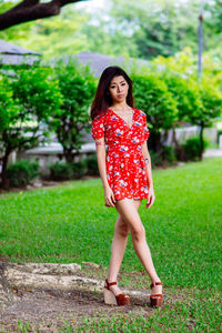 Portrait of young woman standing on field