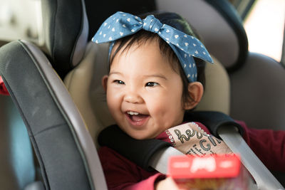 Close-up of cute baby girl in car