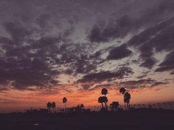 Silhouette people walking against sky during sunset