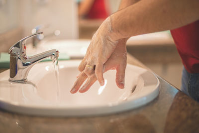 Close-up of hand touching drinking water at home
