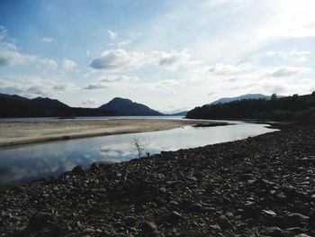 Scenic view of lake against cloudy sky