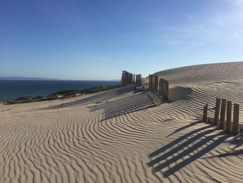 Sand dunes at punta paloma beach against sky