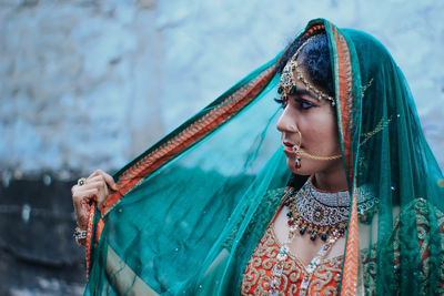 Close-up of woman wearing make-up and jewelry