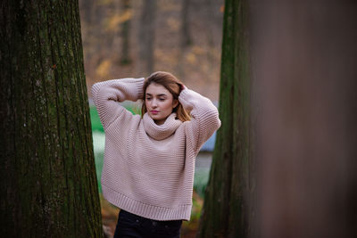 Beautiful young woman standing against plants