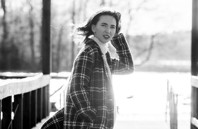 Portrait of young woman standing in city