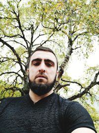 Portrait of young man against tree