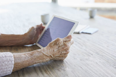 Woman's hands holding digital tablet, close-up