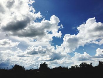 Low angle view of silhouette trees against sky
