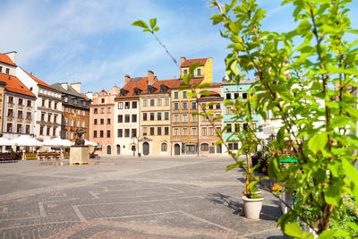 Residential buildings by street against sky