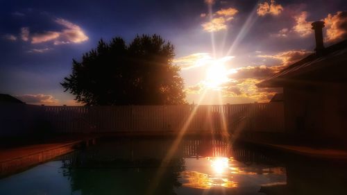 Reflection of trees in water at sunset