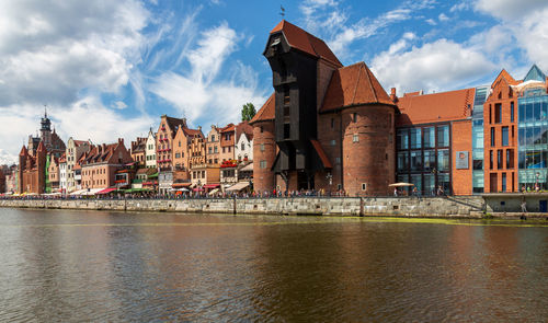 Buildings in city against cloudy sky