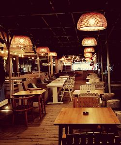 Empty chairs and tables in cafe at night