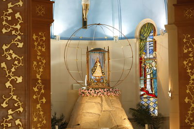 Statue in illuminated temple outside building