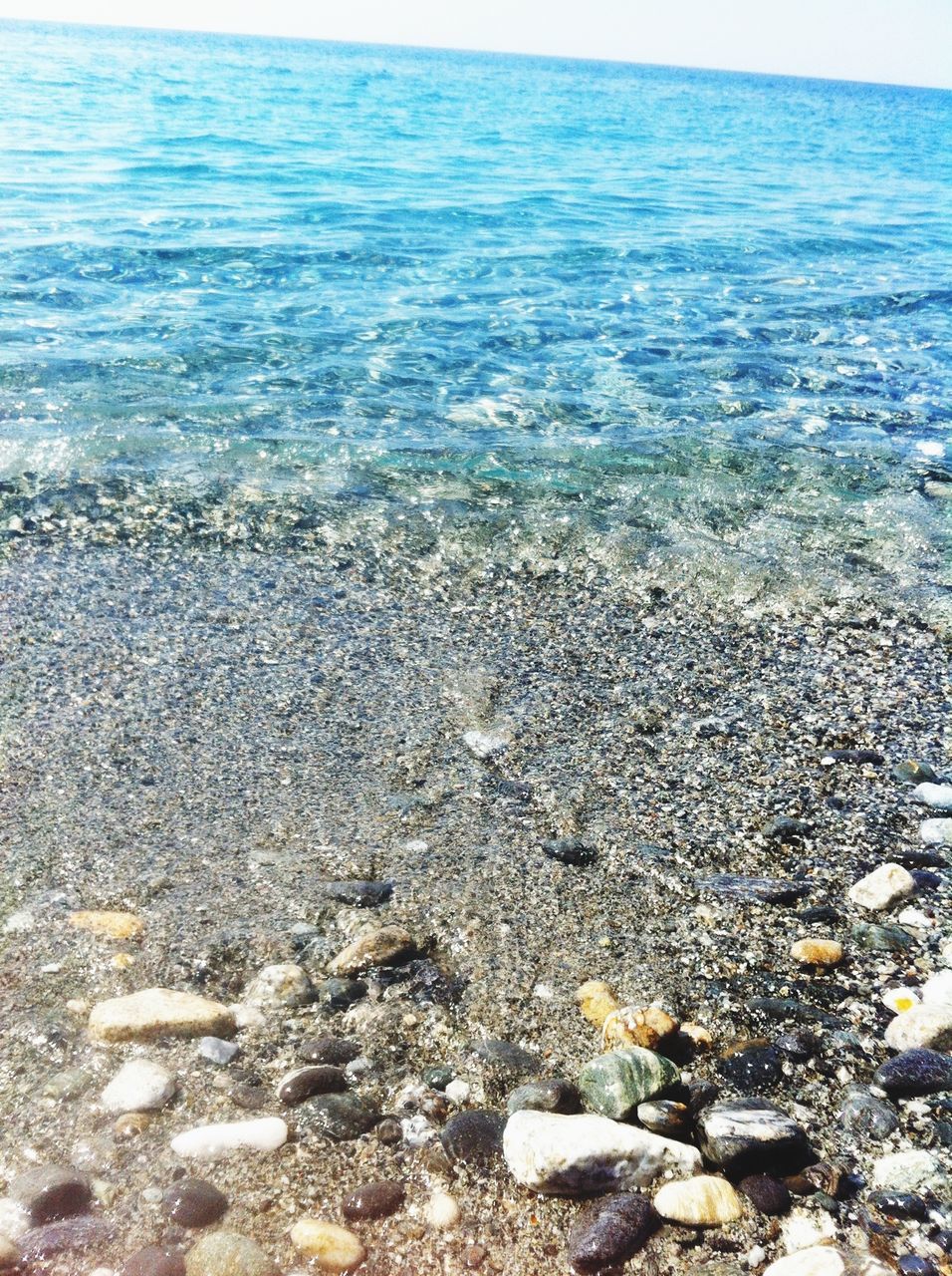 sea, water, beach, horizon over water, shore, scenics, tranquility, tranquil scene, beauty in nature, rock - object, nature, wave, stone - object, pebble, blue, idyllic, rock, coastline, sky, sand