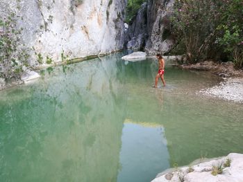 Woman standing on rock by water