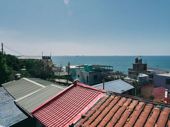 High angle view of buildings by sea against clear sky