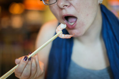 Close-up of woman eating prawn at home