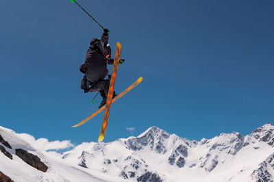 Stylish skiing trick in snowy high sharp mountains. the athlete is flying