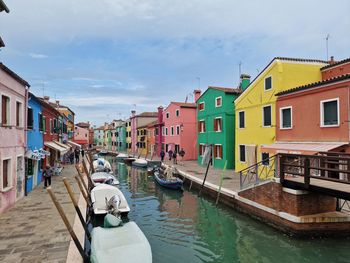 Boats in canal amidst buildings in city