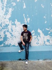 Young man standing against wall