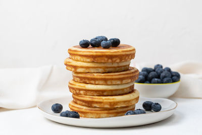 Stack of pancakes on plate with blueberries, side view, copy space