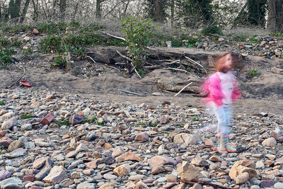 Blurred motion of girl standing on rock