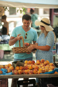 Couple buying fruits at market stall