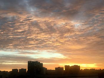 Silhouette cityscape against sky during sunset