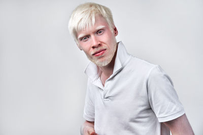 Portrait of smiling man standing against white background