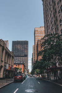 Street amidst buildings in city against clear sky