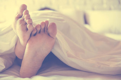 Close-up of woman relaxing on bed at home