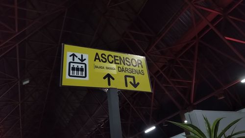 Low angle view of information sign at night