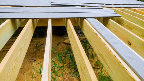 High angle view of wooden bench by building