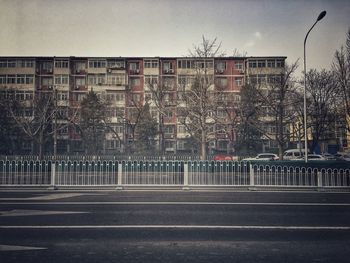 Road by building against sky in city