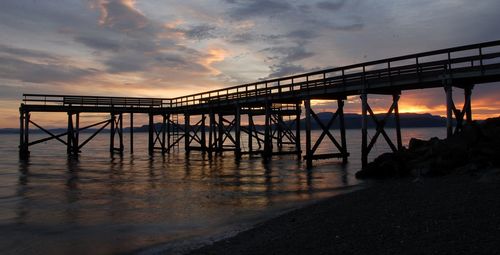 Pier on sea at sunset